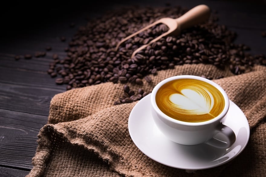 Latte with coffee beans in the background
