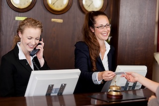 Hotel Receptionist handing over key card to guest